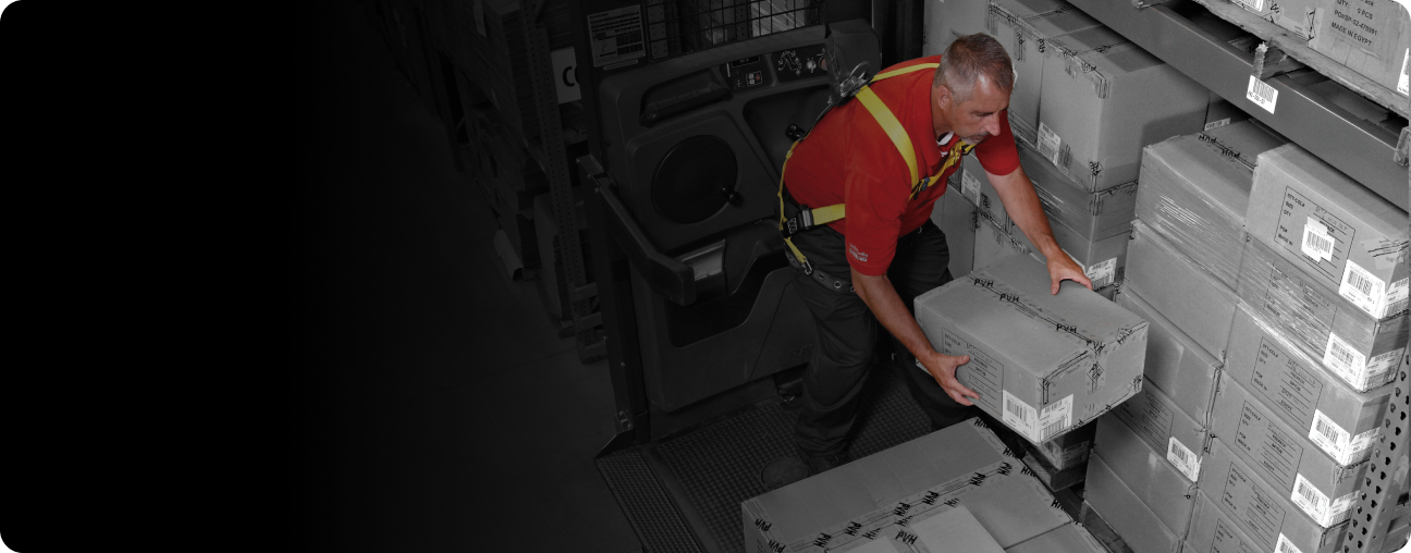 Man order picking packages while on an orderpicker