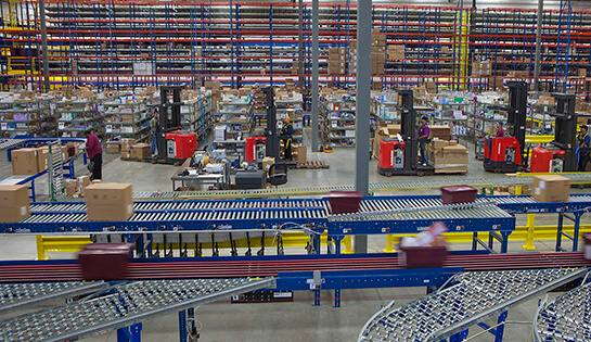Conveyor system in a warehouse with Raymond Forklifts in background