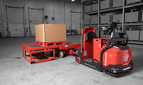 Red Raymond vehicle in warehouse with a box on the back of the Raymond vehicle