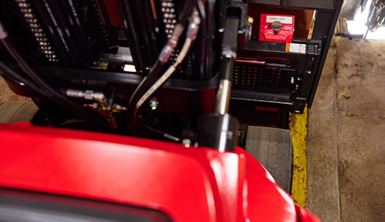 Close-up of mast and hydraulic components on Raymond stand-up forklift.