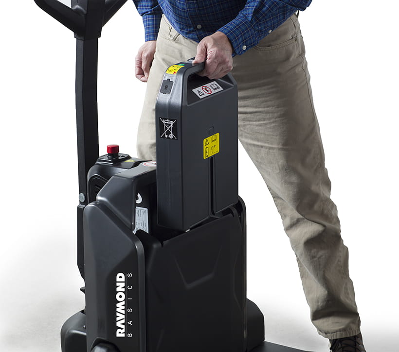 Operator removing battery from Raymond Basics electric pallet jack for charging or replacement
